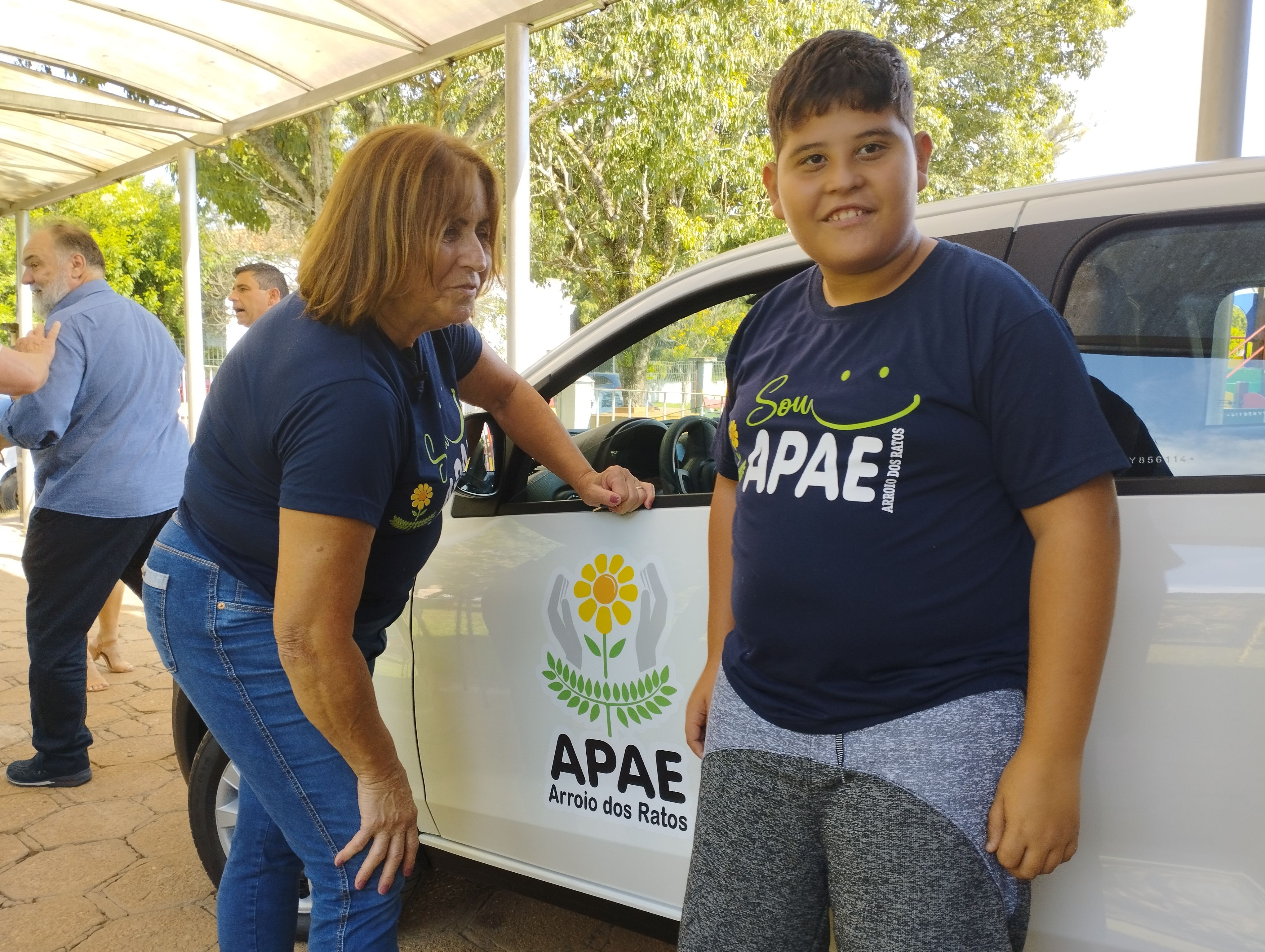 Maria Carolina, Presidente da Apae de Arroio dos Ratos, recebe o autom�vel ao lado de um aluno da in